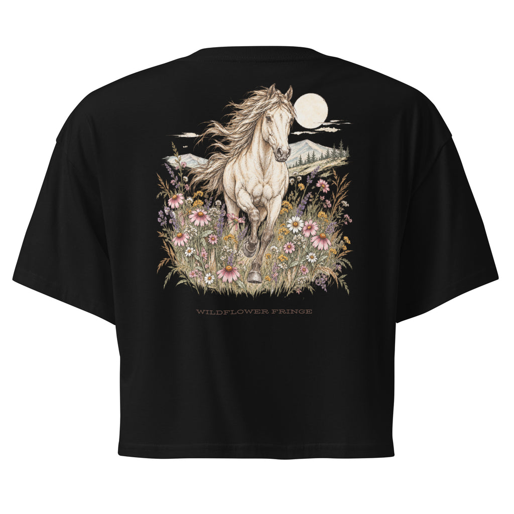 A black short-sleeve crop top shown from the back, featuring a large graphic print of a white horse running through wildflowers under a full moon, with the text 'WILDFLOWER FRANGE' below.