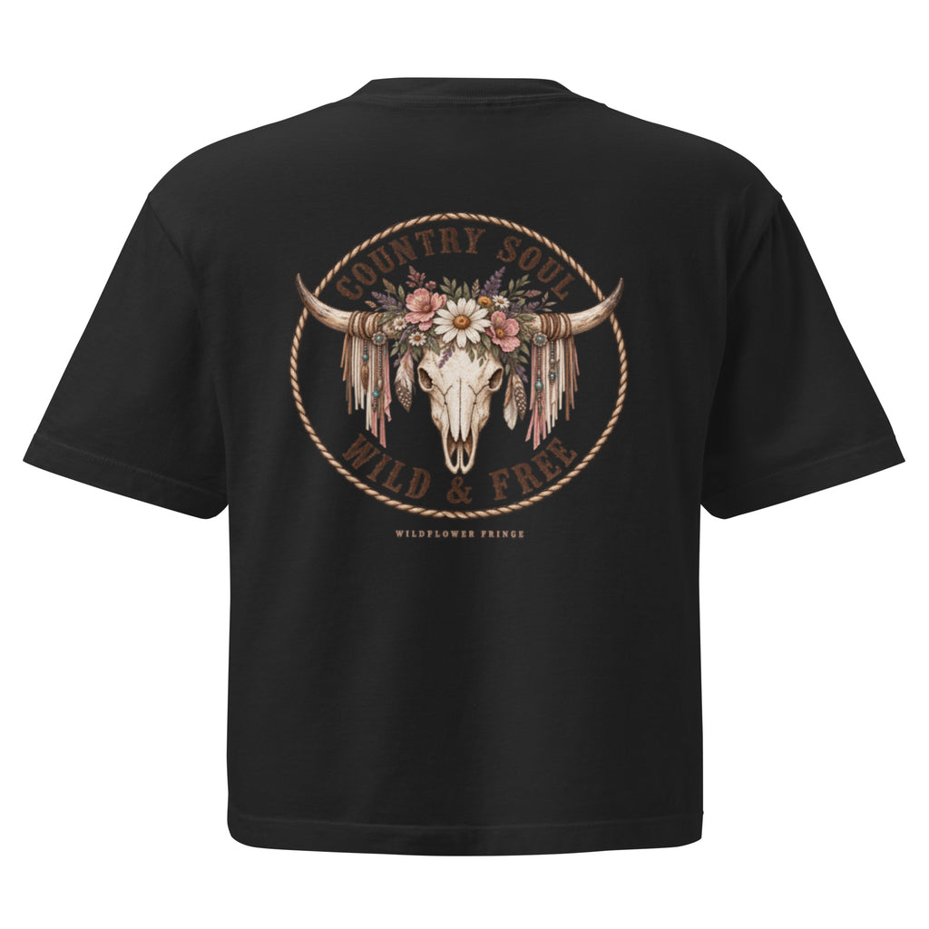 A black short-sleeve t-shirt shown from the back, featuring a large graphic print of a decorated bull skull with feathers and flowers, surrounded by the text 'COUNTRY FOLK WILD & FREE' and 'WILDFLOWER PRINTS'.