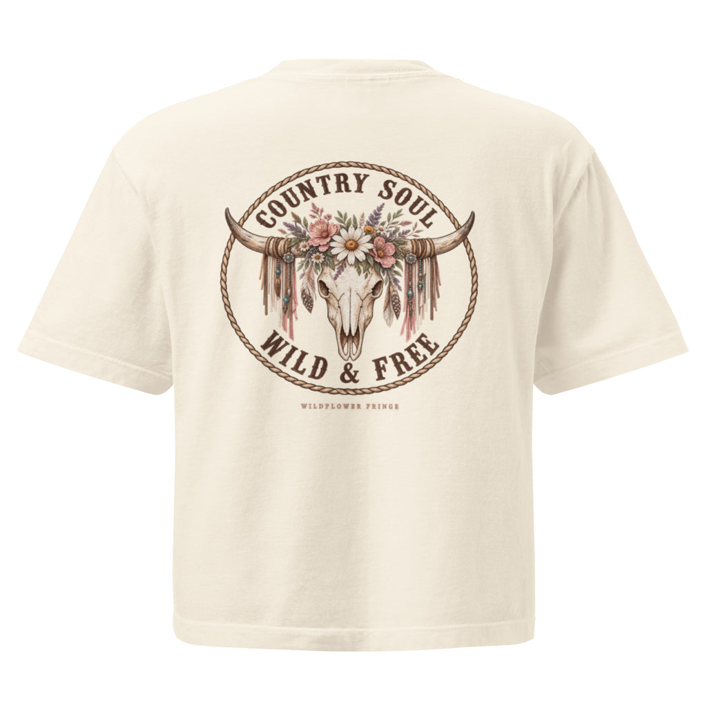 An off-white short-sleeve t-shirt showing the back graphic, which features a circular design with a longhorn skull decorated with flowers and feathers, surrounded by the text 'COUNTRY SOUL WILD & FREE'.
